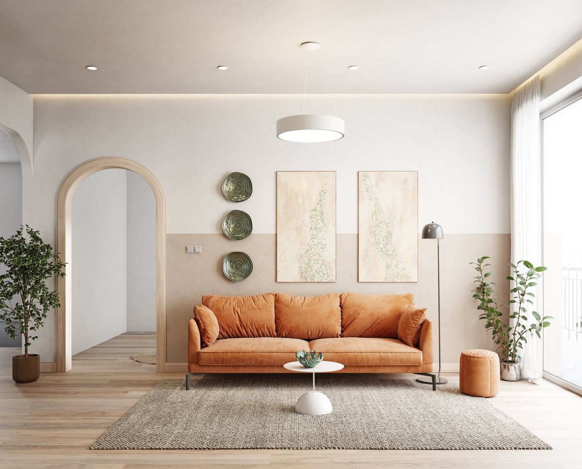 A cozy living room with an orange sofa, plants, and elegant decor